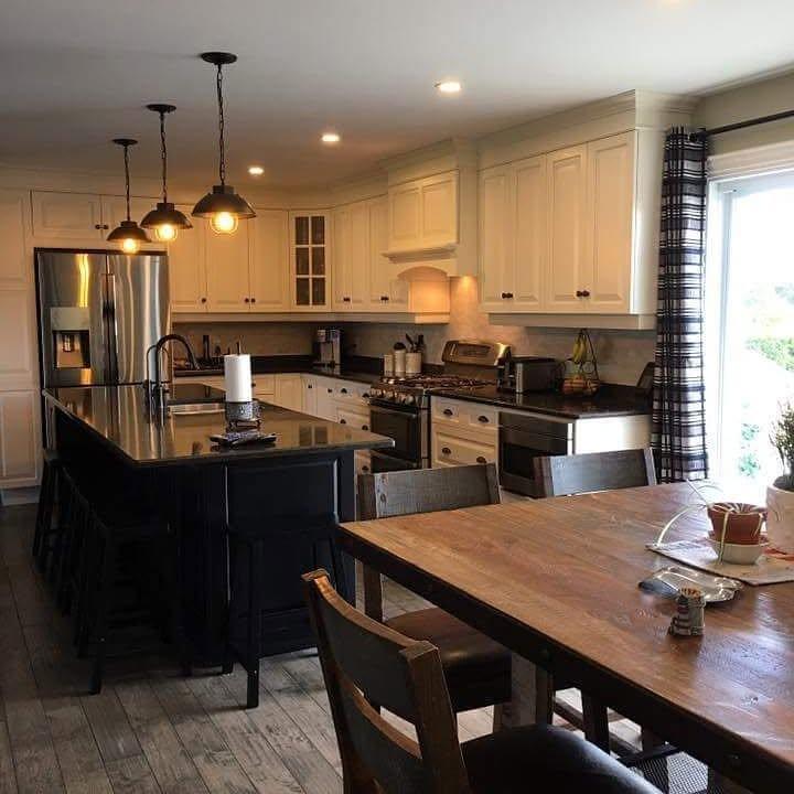 Kitchen island with three pendant lights installed over dark cabinetry